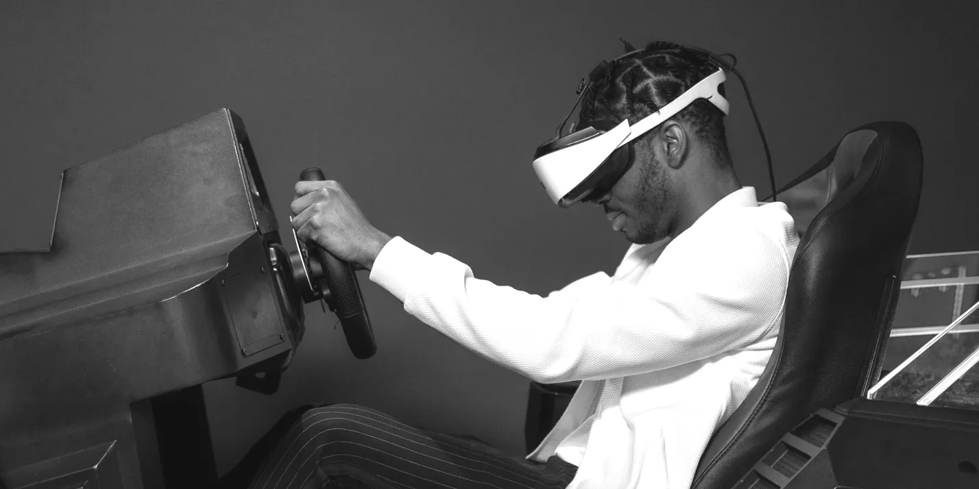 a man in a driving simulator wearing vr goggles